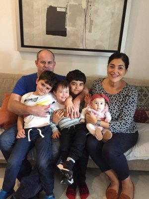 The Holohan family sitting on a couch, with four children on their parents' laps